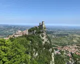 Widok na San Marino z zamkiem na skale. Idealne miejsce, by sprawdzić, jak dojechać z Rimini do San Marino.