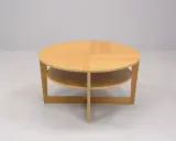 Rundt, ljust träbord med två hyllplan, en klassisk IKEA VEJMON EK. Perfekt för vardagsrummet.
