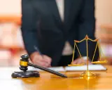 Młotek sędziowski i waga sprawiedliwości na biurku. Sąd rozstrzyga podział majątku, wyznaczając właściwość sądu.