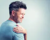 Homme souffrant de douleurs articulaires à l'épaule, possiblement liées à une carence en vitamine B12.