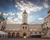 Piękny dziedziniec zamku Krasiczyn zachęca do zwiedzania. Architektura zachwyca pod błękitnym niebem.