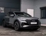 Grauer Audi q4 e tron steht vor einer Garage.