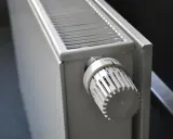 Biały grzejnik aluminiowy z termostatem. Dowiedz się, jak wyczyścić grzejnik aluminiowy w środku, by działał sprawniej.