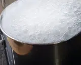 Gęsta piana z wrzącej wody w garnku, gotowanie wody na kuchence.