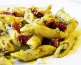 Penne z pesto i kawałkami suszonych pomidorów, posypane parmezanem. Pyszne danie, które zachwyci każdego miłośnika makaronu z suszonymi pomidorami.