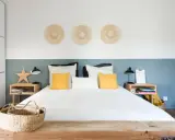 Décoration murale avec trois chapeaux de paille pour comment donner de la hauteur à un plafond bas. Chambre moderne et lumineuse.