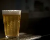Szklanka złocistego piwa bezalkoholowego, z obfitą pianką i bąbelkami, idealna dla alkoholika szukającego alternatywy.