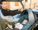 Padre atento conduce mientras su bebé duerme plácidamente en su silla de auto, listo para viajar con bebes.