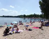 Słoneczny dzień nad zalewem Sosina. Ludzie odpoczywają na plaży, kąpią się i opalają.