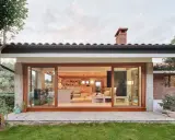 Ristrutturazione esterna di una casa anni '70: un'oasi moderna con ampie vetrate che si aprono sul verde.