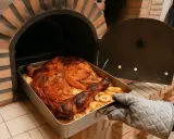 Pollo dorado y jugoso, listo para ser servido, recién sacado de los asados en horno de leña.
