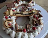 Gâteau d'anniversaire en forme de chiffres, décoré de crème fouettée, de biscuits lettres formant "CLEM", de chocolats et de bonbons. Quelle crème pour recouvrir un gâteau ? Celle-ci est parfaite !