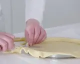 Préparation de la pâte pour une recette biscuit noisette. Les mains ajustent la pâte dans un moule à tarte.