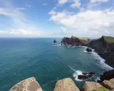 Steile Klippen und das weite Meer vor Madeira im Oktober. Das Wetter ist wechselhaft, aber die Aussicht ist atemberaubend.