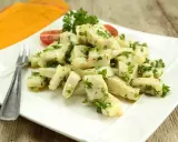 Délicieuse seiche en persillade, servie sur une assiette blanche avec une touche de tomate et de persil frais. Un plat savoureux et léger.