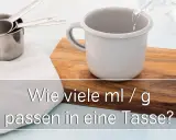 Messbecher und eine Tasse, in die Wasser gegossen wird. Die Frage "wie viel gramm hat eine tasse" wird thematisiert.