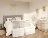 Une chambre beige cocooning avec un lit douillet, des coussins moelleux, une couverture texturée et une décoration murale en macramé.