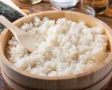 Gotowany ryż do sushi w drewnianej misce z drewnianą łyżką.