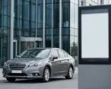 Szary sedan przed nowoczesnym budynkiem. Szybka rejestracja samochodu online to klucz do sprawnego załatwienia formalności.