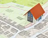 Model domu na tle mapy z zaznaczonymi działkami i oznaczeniami. To wizualizacja miejscowych planów zagospodarowania przestrzennego.