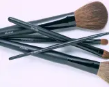 Un conjunto de brochas de maquillaje negras etiquetadas como "blusher", "blender", "eyeshadow", "powder" y "make-up". Aprende como limpiar brochas de maquillaje para mantenerlas en perfecto estado.