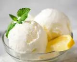 Delicioso helado de limón casero en copa de cristal, adornado con menta fresca y rodajas de limón.