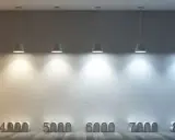 Rząd lamp oświetla ścianę od ciepłego, pomarańczowego światła (1000 K) po zimne, niebieskie (10000 K), pokazując różne barwy światła.