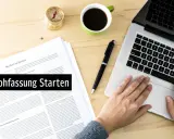 Hände tippen auf Laptop, daneben liegen Dokumente und Kaffee. So wie hier, kann man eine Gedichtinterpretation beginnen.