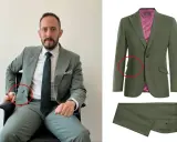 Man in a sage green suit with a ticket pocket, showing off the suit's details.