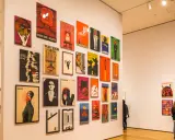 Vibrant posters adorn a gallery wall, showcasing diverse graphic design. This exhibition highlights some of the best art cities in the US.