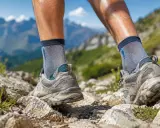 Nogi w butach trekkingowych na lato, pokonujące kamienisty szlak w górach. Idealne, by cieszyć się wędrówką.