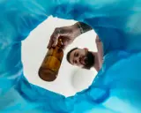 Mężczyzna wyrzuca butelkę, symbolizując wolność i nowe życie bez alkoholu.