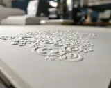 Elegancki wzór kwiatowy wykonany techniką druku wypukłego na białym papierze.