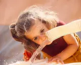 Ein Kleinkind trinkt zu wenig, deshalb wird ihm Wasser aus einem Schlauch direkt in den Mund gegeben.
