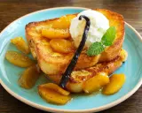 Délicieux pain perdu brioché, garni de fruits caramélisés, d'une boule de glace à la vanille et d'une gousse de vanille.