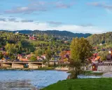 Widok na malownicze ulice w Szczawnicy, z domami na zboczach gór i rzeką w tle.