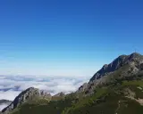Giewont wysokość 1894 m n.p.m. widoczna z grani, morze chmur poniżej, błękitne niebo.