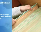 Maintenant, vous savez combien de temps garder les quittances de loyer. Une main trie des dossiers suspendus dans un classeur.