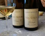 Verre de vin blanc et deux bouteilles Paul Kubler, Riesling et Gewurztraminer. Quel vin pour cuire la choucroute ? Le Gewurztraminer est un excellent choix.