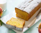 Un delizioso plumcake alle mele, cosparso di zucchero a velo, con una fetta già tagliata. Mele rosse e un bicchiere di latte completano la scena.