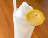 Un refrescante granizado de limón, coronado con una rodaja de limón, perfecto para un día caluroso.