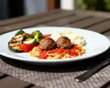Boulettes de viande sur pâtes avec sauce tomate, purée et légumes grillés. La meilleure sauce pour boulette de viande, c'est celle-ci !