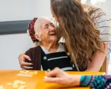 Giovane abbraccia anziana sorridente, un momento di affetto che contrasta il timore del decadimento cognitivo improvviso.