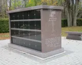 Mauzoleum z miejscami na urny, symbolizujące jak wygląda pochówek urny. Kamienna ławka obok.