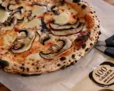 En nybakad champinjonpizza med bubblande ost, redo att skäras med saxen. En perfekt pizza för alla som gillar 400grader recensioner.