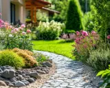 Ein schöner Weg lädt ein, den Garten gestalten mit wenig Geld. Blumen und Steine schaffen eine idyllische Atmosphäre.