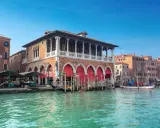Le marché du Rialto à Venise, avec ses étals colorés et ses gondoles sur le Grand Canal.