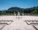 Cmentarz żołnierzy polskich, gdzie jest Monte Cassino. Monumentalny widok na wzgórze z opactwem, schody, krzyże i kamienne nagrobki.