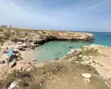 Una splendida giornata alla spiaggia di Porto Verde, con bagnanti che si godono il sole e le acque cristalline.