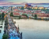 Tłum ludzi na moście Karola w Pradze, w tle widać zamek. Ceny w Czechach mogą być zaskoczeniem dla turystów.